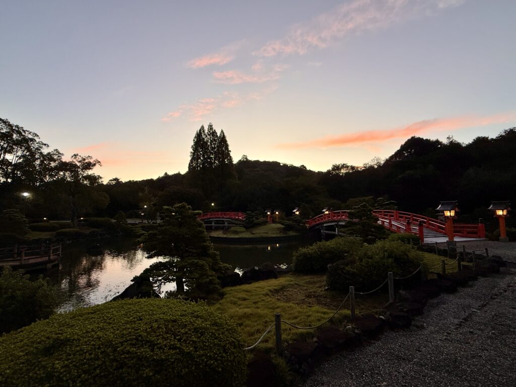 神嘗祭のころ境内にて朱橋にともる灯、東雲の色…水面にも映る